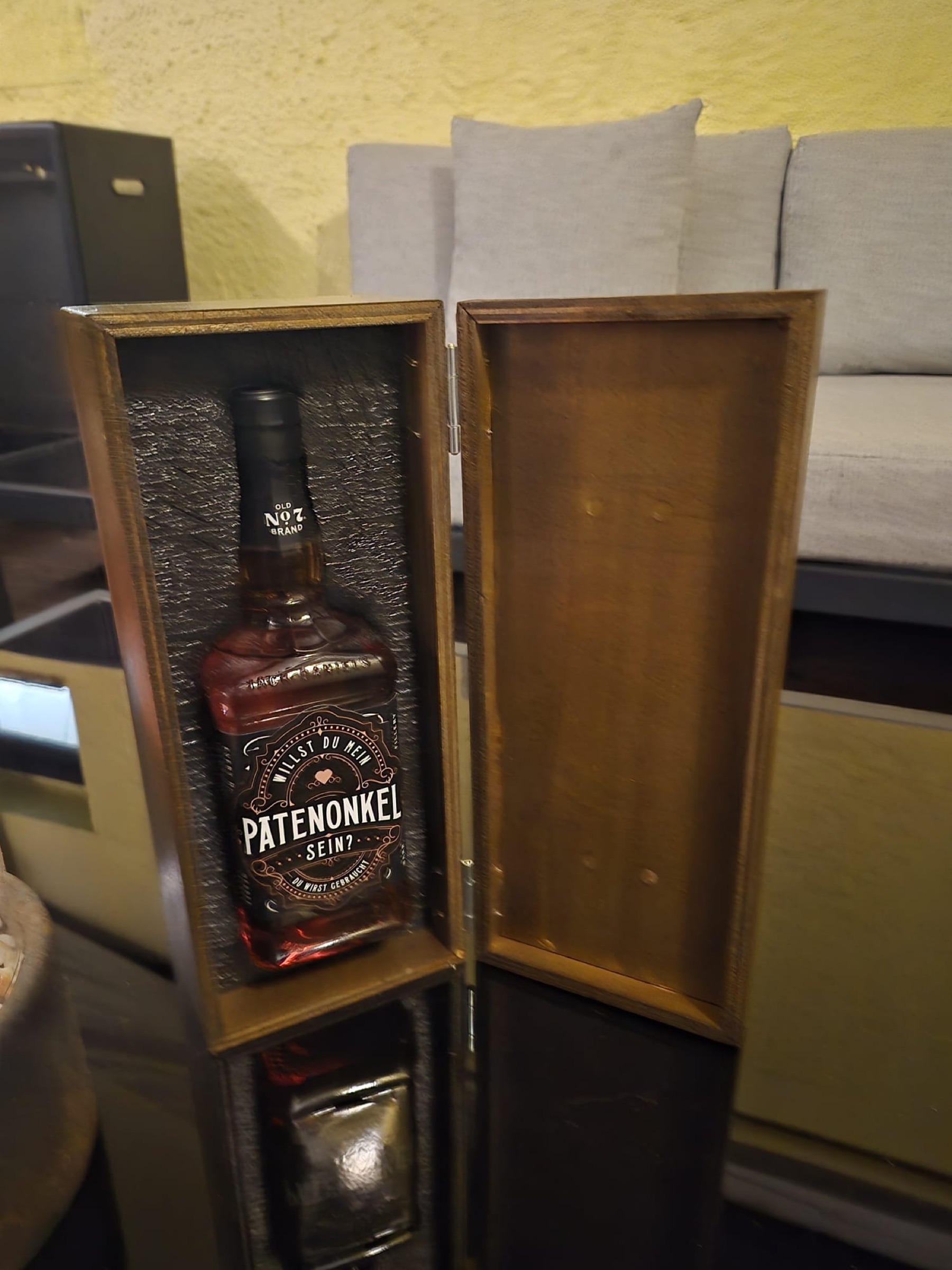 Geöffnete Geschenkbox aus Holz mit einer Whiskyflasche als personalisierte Geschenkidee für einen Patenonkel